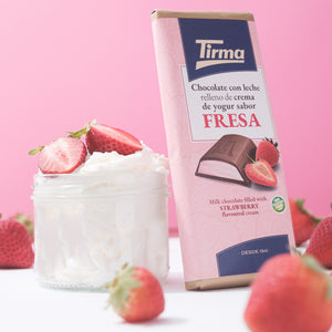 Tirma strawberry-flavored chocolate bar with a dessert and strawberries on a pink background