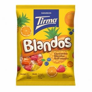 A bag of Tirma Blandos Caramelos soft sweets, featuring a bright yellow packaging with illustrations of fruits like pineapple, orange, strawberry, and blueberries, and the Tirma brand logo in a blue box at the top.