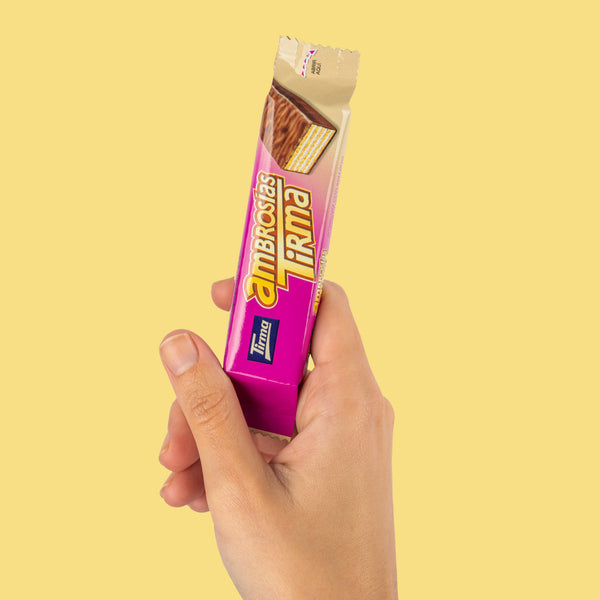 Hand holding a single milk chocolate wafer by Tirma, 21.5g. Made in Spain.