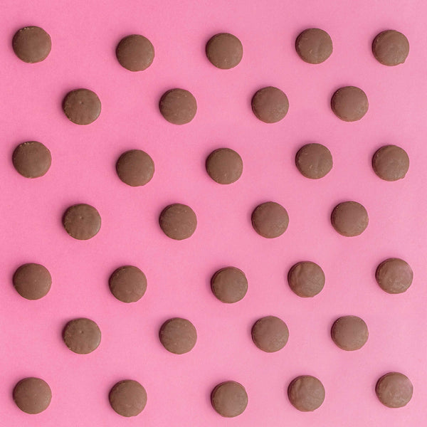 Tirma Mini Milk Chocolate Covered Biscuit 160 g in an organized 32 biscuits in a pink background. Spanish mini biscuits made in Spain.