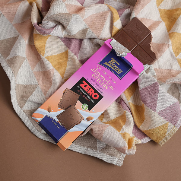 Tirma Milk Chocolate Bar with Whole Almonds, No Added Sugars, 125g. Made for sharing - A gluten free chocolate bar placed on a scarf. Spanish chocolate made in Spain.