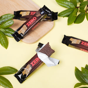 Tirma's 3 closed and 1 open 70% Dark Chocolate Wafers. Placed on a yellow background with green leaves and a cheese serving board. Tirma's Chocolate Wafers Photography. 70% Dark Chocolate Spanish wafers in the UK