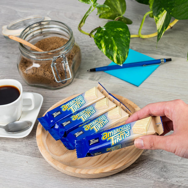 4 Tirma White Chocolate Wafers on a wooden plate with coffee, brown sugar, money plant and a pencil and blue Post-it sticky notes.